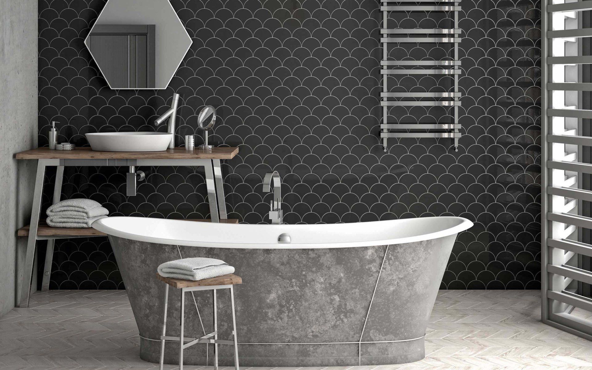 réhabilitation d'architecte d'une salle de bain avec mosaïque de carreaux noirs et baignoire îlot en zinc accompagnée d'un plan vasque en bois sur pieds métalliques, vasque à poser en céramique et miroir octogonal